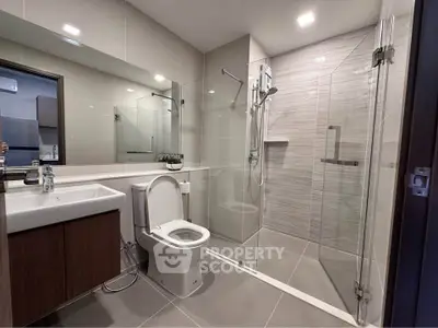 Modern bathroom with glass shower and sleek fixtures in contemporary home.