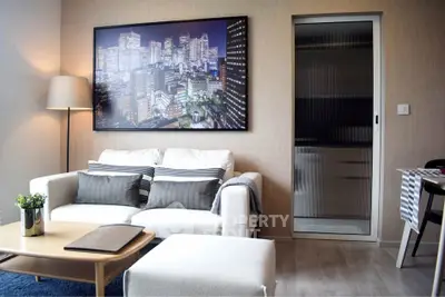 Modern living room with stylish decor and cityscape artwork, featuring a cozy sofa and elegant lighting.