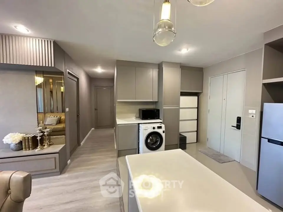 Modern open-plan kitchen with sleek appliances and stylish decor in a contemporary apartment.
