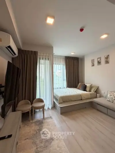 Modern bedroom with large windows and stylish decor in a cozy apartment.