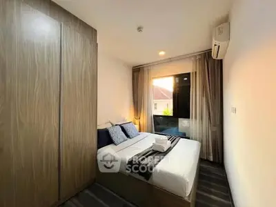 Cozy bedroom with modern decor and large window offering natural light