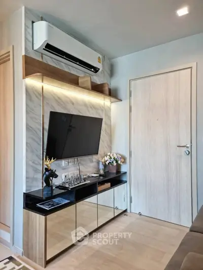Modern living room with sleek TV unit and air conditioning, featuring stylish decor and elegant lighting.