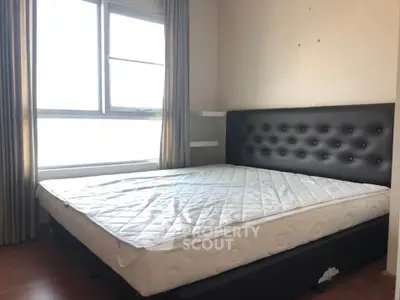 Spacious bedroom with large window and modern bed frame, perfect for natural light lovers.
