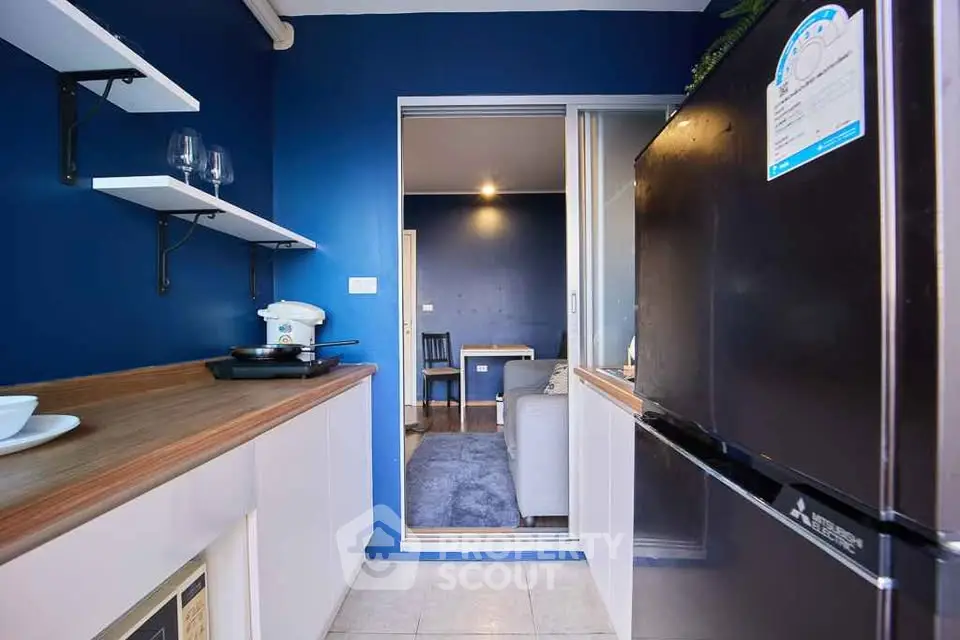 Modern kitchen with sleek appliances and open layout leading to cozy living area.