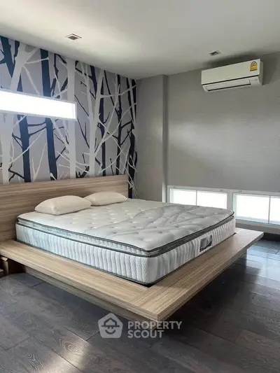 Modern bedroom with stylish wallpaper and sleek wooden bed frame, featuring a comfortable mattress and air conditioning.