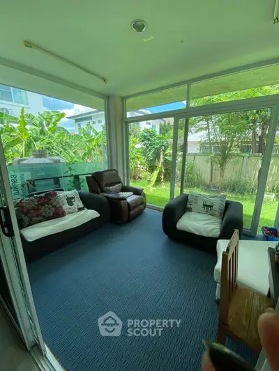 Cozy sunroom with garden view and modern seating