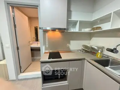 Modern kitchen with sleek cabinetry and adjacent bathroom view