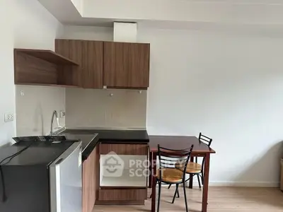 Compact kitchen with wooden cabinets and dining set in modern apartment