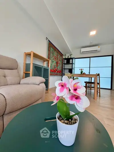 Modern living room with stylish decor and natural light, featuring a cozy sofa and elegant dining area.
