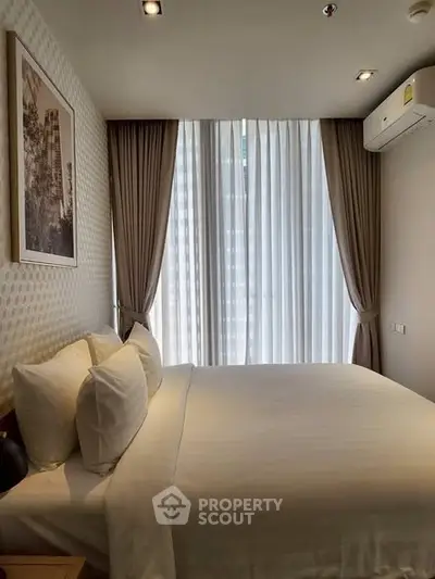 Cozy bedroom with elegant decor and large window drapes