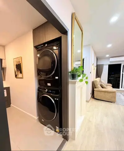 Modern apartment interior with stacked washer-dryer and cozy living room