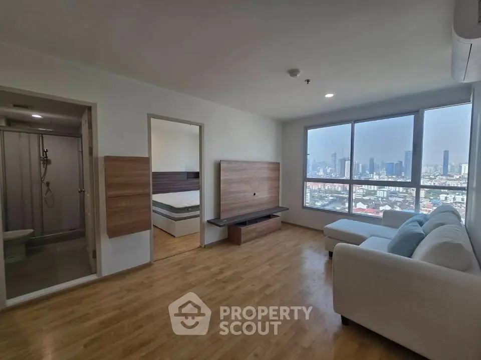 Spacious modern living room with city view and adjacent bedroom in high-rise apartment.