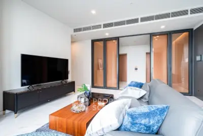Luxurious modern living room with sleek design and large TV, perfect for relaxation and entertainment.