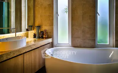 Luxurious bathroom with elegant bathtub and modern fixtures, featuring large windows for natural light.