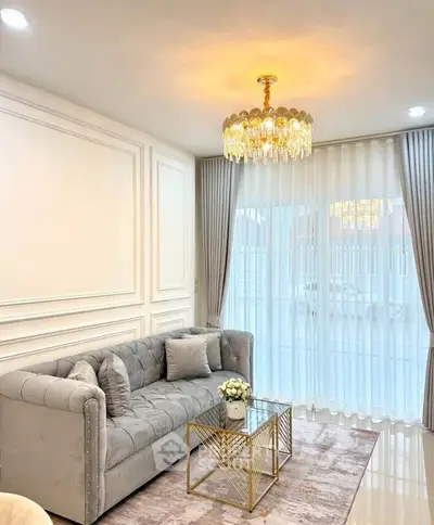 Elegant living room with plush gray sofa and crystal chandelier