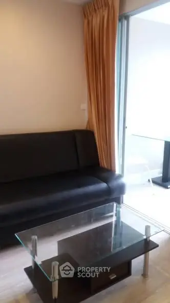 Modern living room with glass coffee table and balcony view