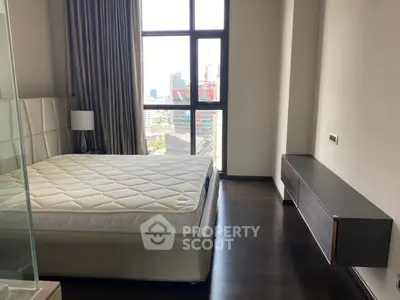 Modern bedroom with large window offering city view, featuring sleek design and natural light.