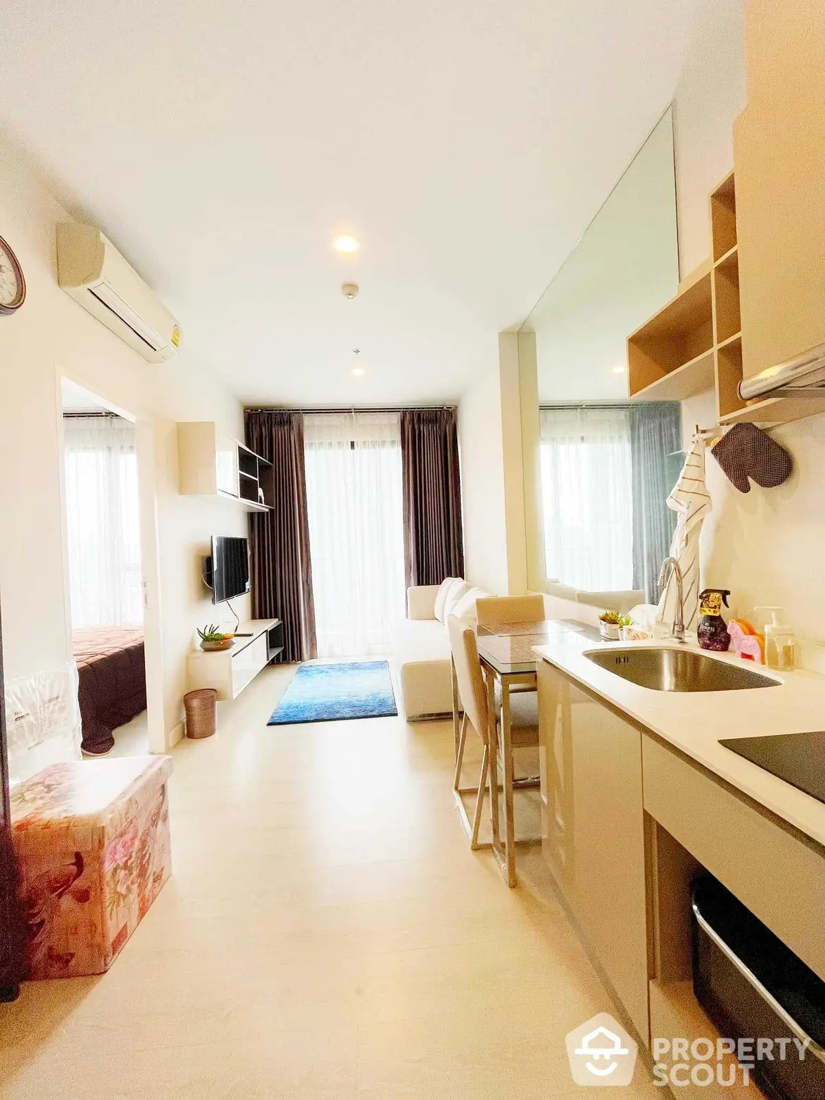 Bright and cozy studio apartment with modern open kitchen layout, comfortable living space, and ample natural light.