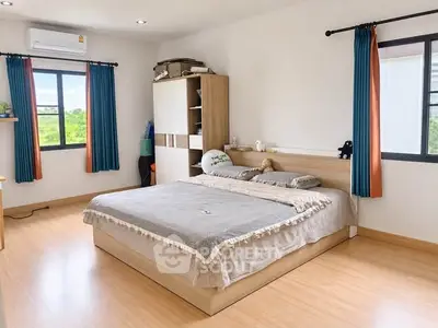 Spacious bedroom with large windows and modern furnishings, offering a bright and inviting atmosphere.