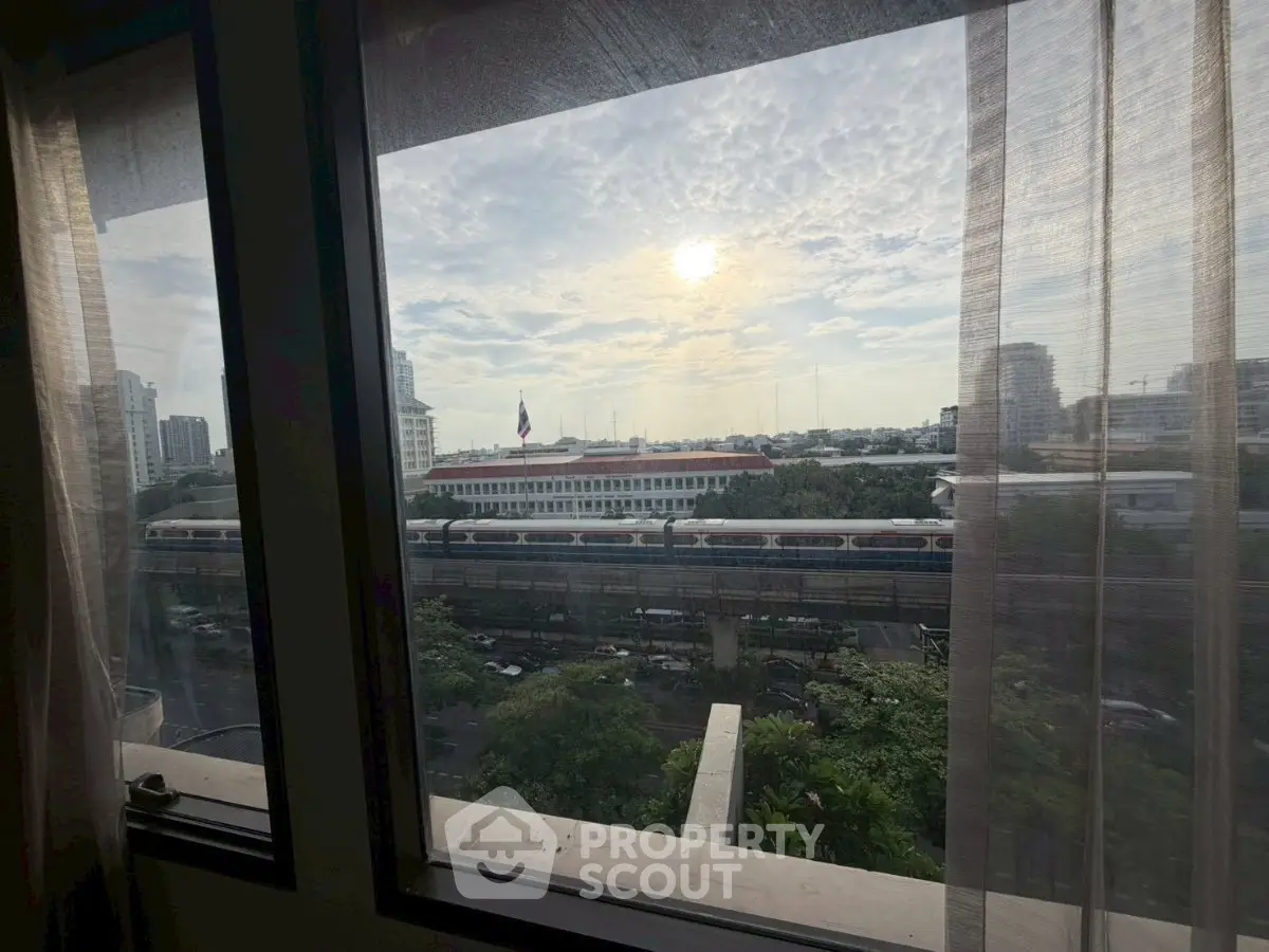 Stunning cityscape view from a high-rise apartment window, showcasing urban skyline and vibrant city life.