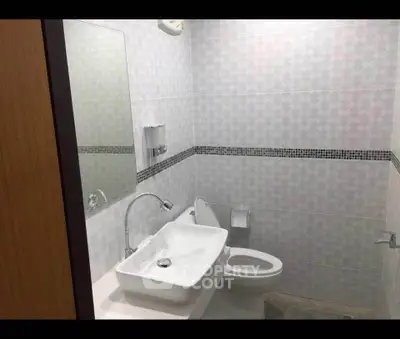 Modern bathroom with sleek white fixtures and stylish tile design.