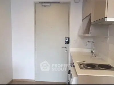 Compact modern kitchen with electric stove and sleek cabinetry in a cozy apartment.