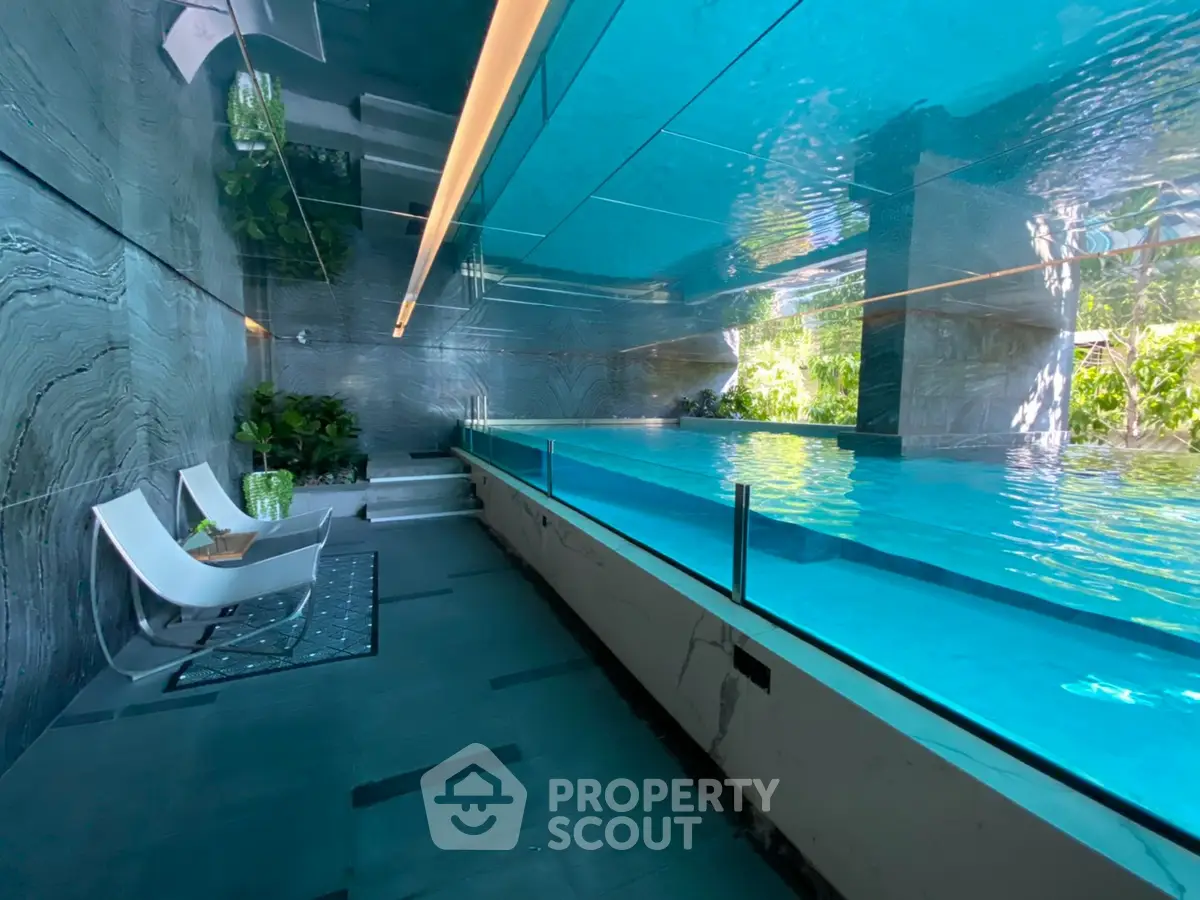 Luxurious indoor pool with modern design and lush greenery, perfect for relaxation and leisure.