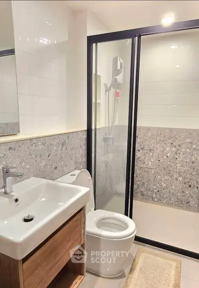 Modern bathroom with sleek shower and stylish sink in contemporary apartment.