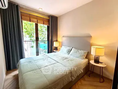 Cozy bedroom with large window and elegant decor, perfect for relaxation.