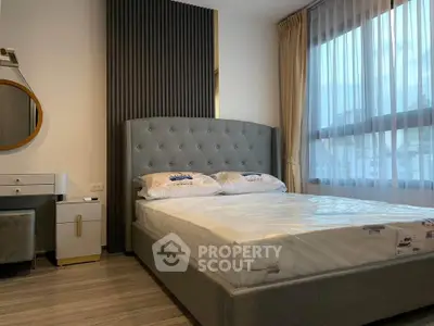 Modern bedroom with stylish bed and large window in a contemporary apartment.