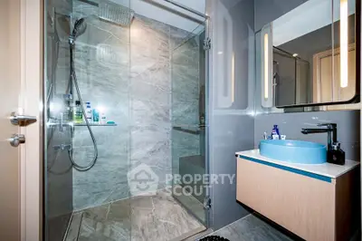 Modern bathroom with glass shower and stylish vanity in luxury apartment