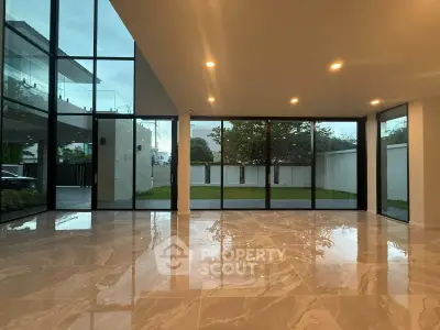 Spacious modern living room with floor-to-ceiling windows and glossy marble flooring.