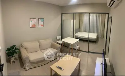 Modern studio apartment with glass partition, cozy living area, and minimalist decor.