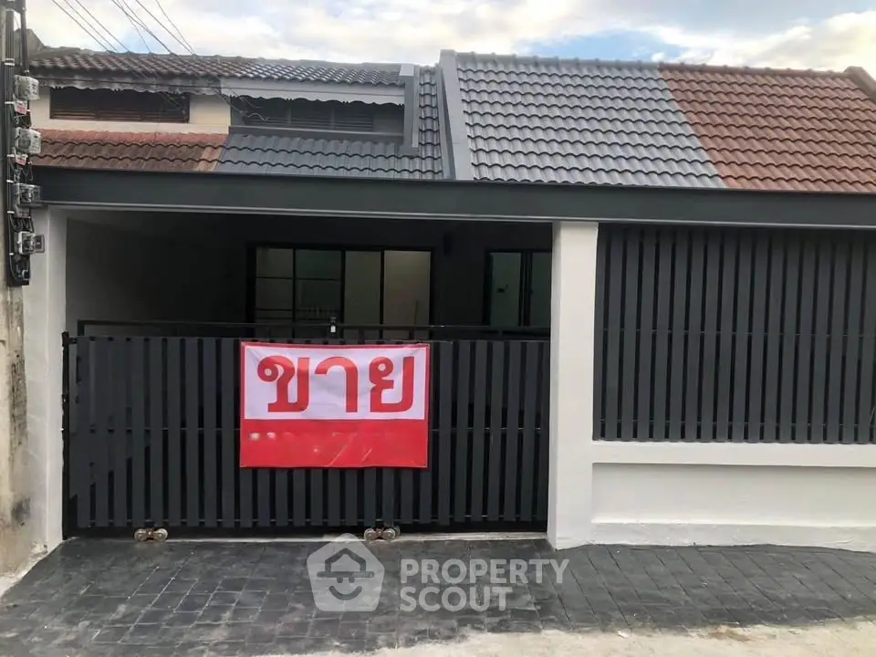 Charming single-story home with modern facade and gated entrance for sale.
