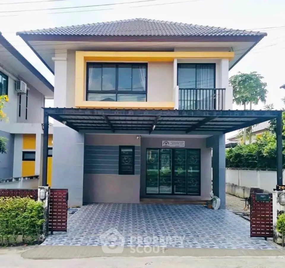 Modern two-story house with tiled driveway and balcony in a suburban neighborhood.