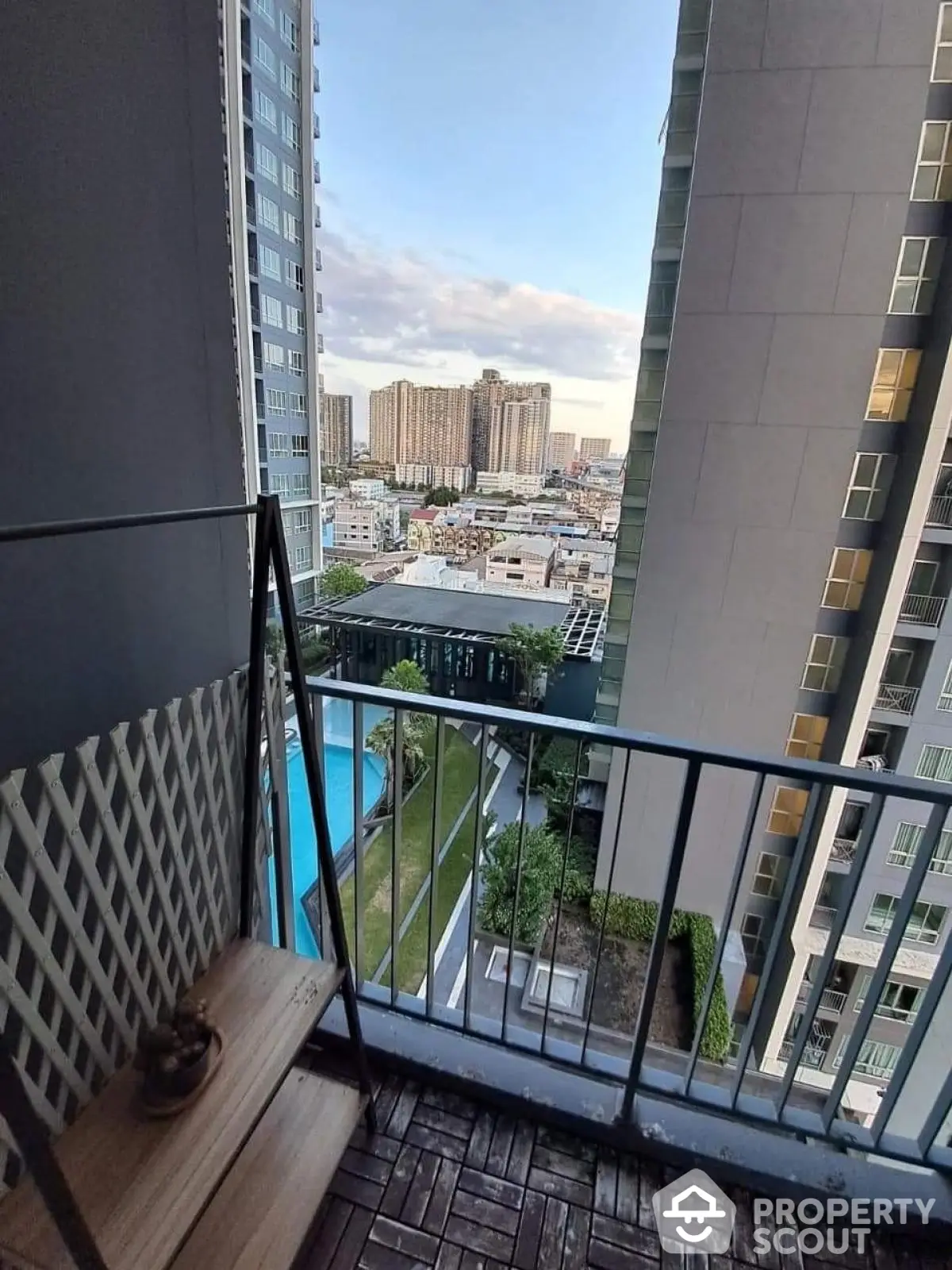 Stunning high-rise balcony view with pool and cityscape