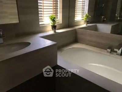 Luxurious bathroom with elegant bathtub and natural light through blinds