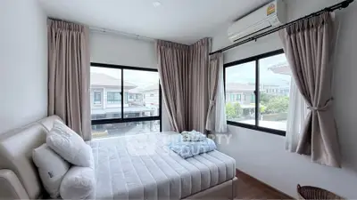 Bright bedroom with large windows and modern decor in a stylish home.