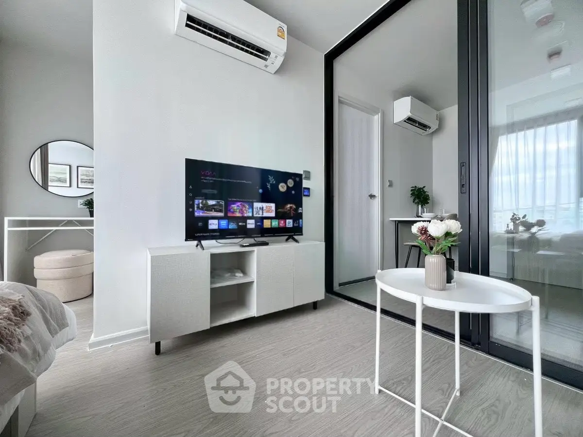 Modern living room with sleek design, featuring a TV, air conditioning, and stylish decor.