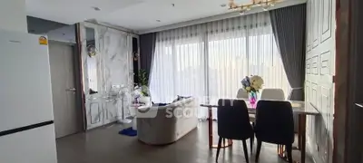 Modern living room with elegant decor and large windows offering city views