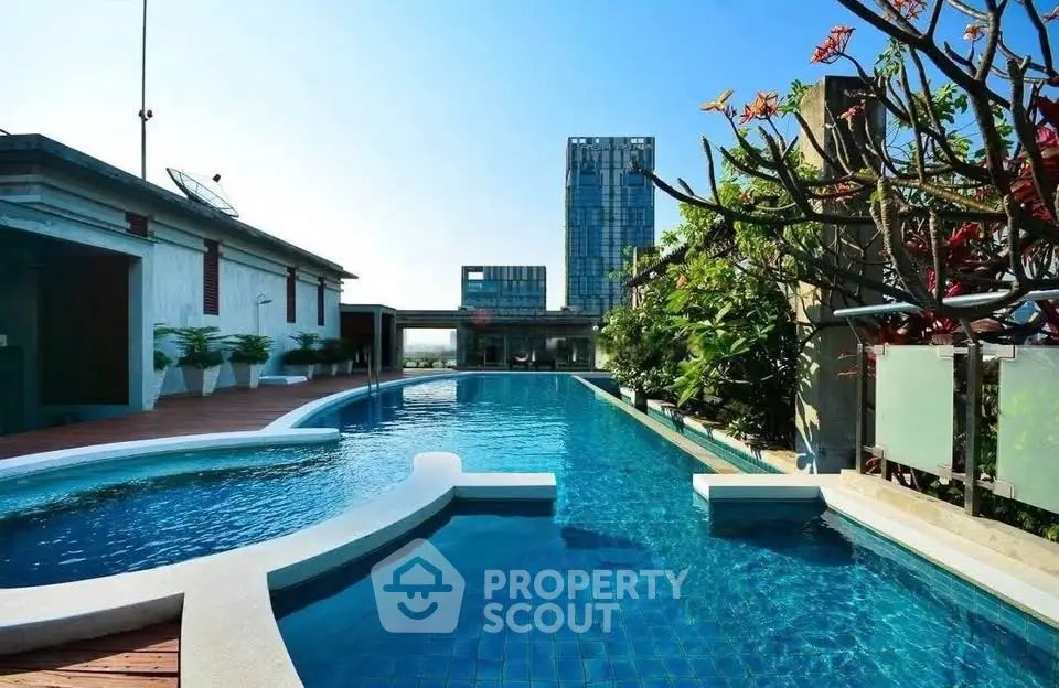 Luxurious rooftop pool with stunning city views and lush greenery, perfect for relaxation and leisure.