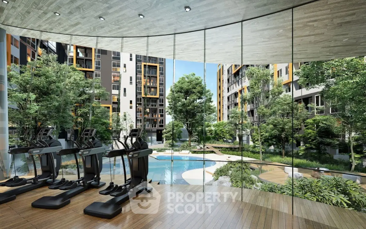Luxurious gym with panoramic view of lush garden and pool in modern apartment complex.