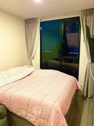 Cozy bedroom with large window offering city view, featuring elegant curtains and stylish bedding.