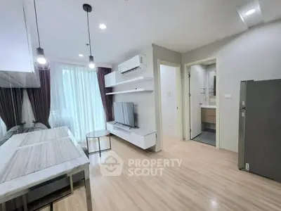 Modern living room with sleek design, featuring wooden flooring, stylish lighting, and a large window for natural light.