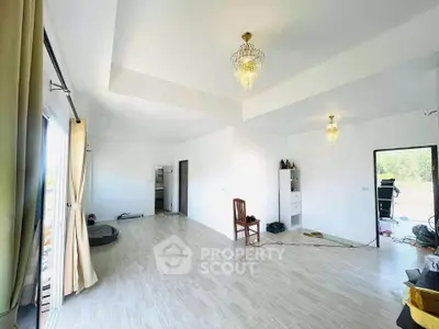 Spacious living room with elegant chandeliers and natural light