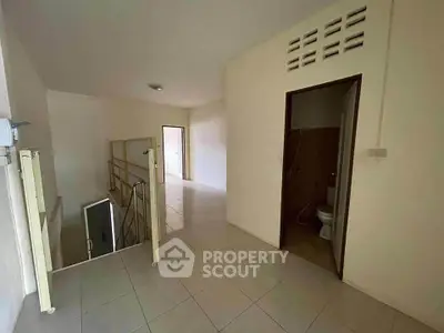 Spacious hallway with tiled flooring and adjacent bathroom in modern home.