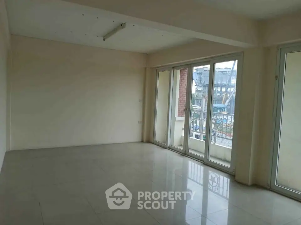 Spacious empty room with large windows and tiled floor, perfect for customization.