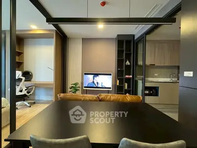 Modern open-plan living area with sleek kitchen and cozy workspace