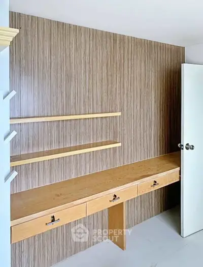 Modern study room with built-in wooden desk and shelves, perfect for productivity.
