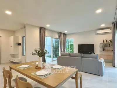 Spacious modern living room with elegant decor and large windows offering natural light.